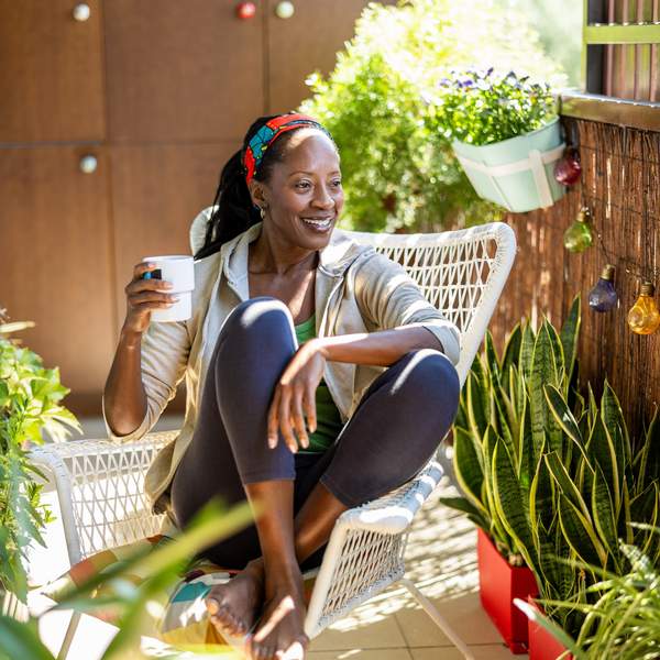 Mature woman enjoying quiet time outdoors on her balcony, representing life after menopause with peace and strength