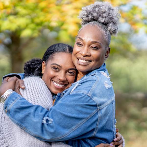 Mother and daughter smiling while they embrace each other