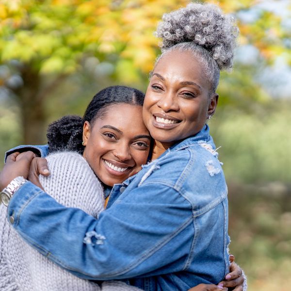 Mother and daughter smiling while they embrace each other