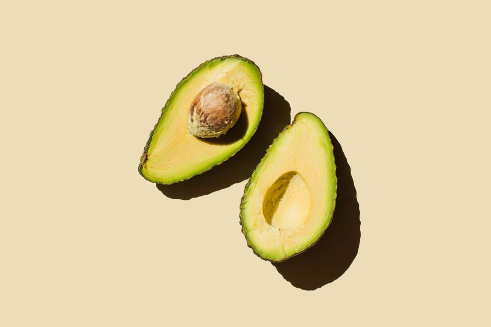 Ripe-avocado-in-halves-against-beige-background