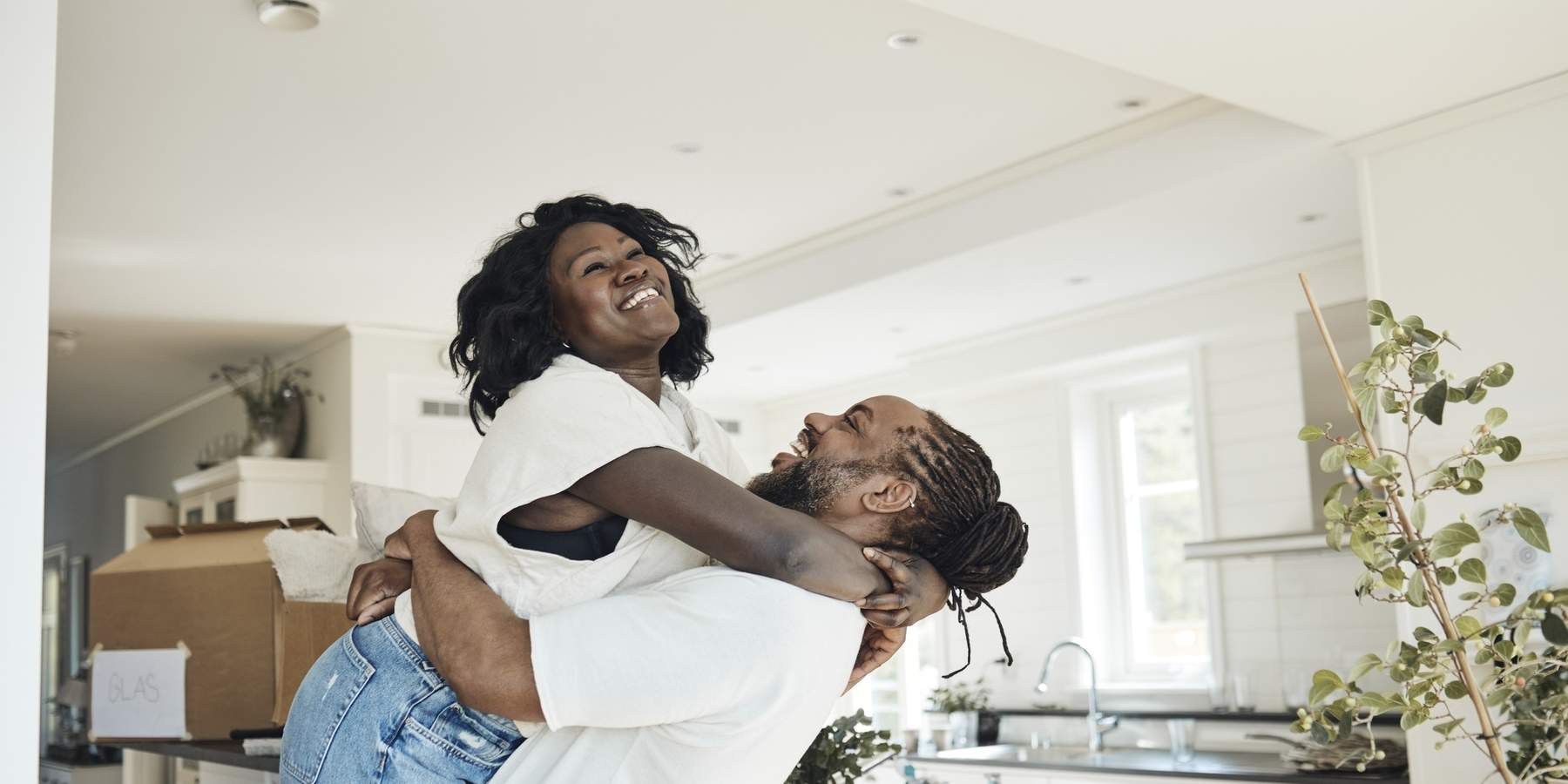 side-view-of-happy-boyfriend-lifting-girlfriend-while-standing-at-home