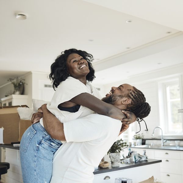 side-view-of-happy-boyfriend-lifting-girlfriend-while-standing-at-home