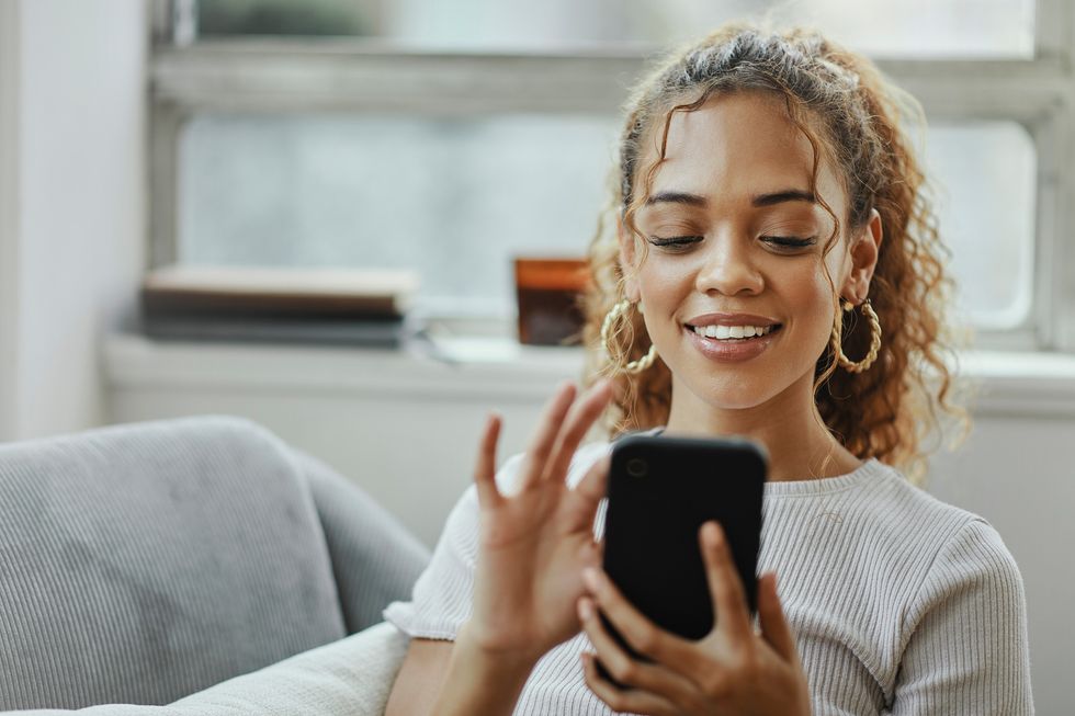 Smiling-Black-woman-scrolling-on-her-phone
