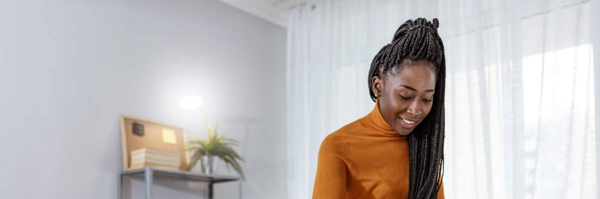 Smiling-Black-woman-with-braids-organizing-her-work-space
