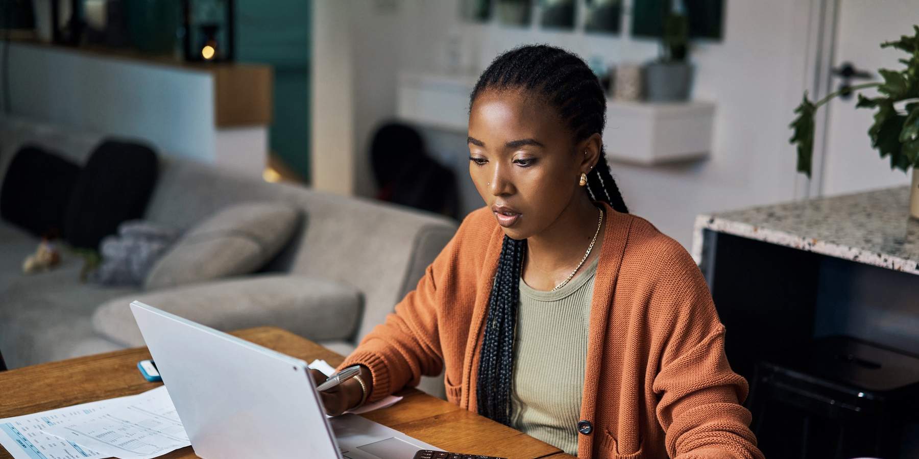 Stressed-woman-with-braids-calculating-expenses-from-assorted-reciepts