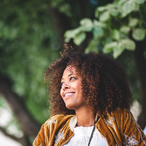thoughtful-black-woman-with-curly-hair-looking-away-smiling
