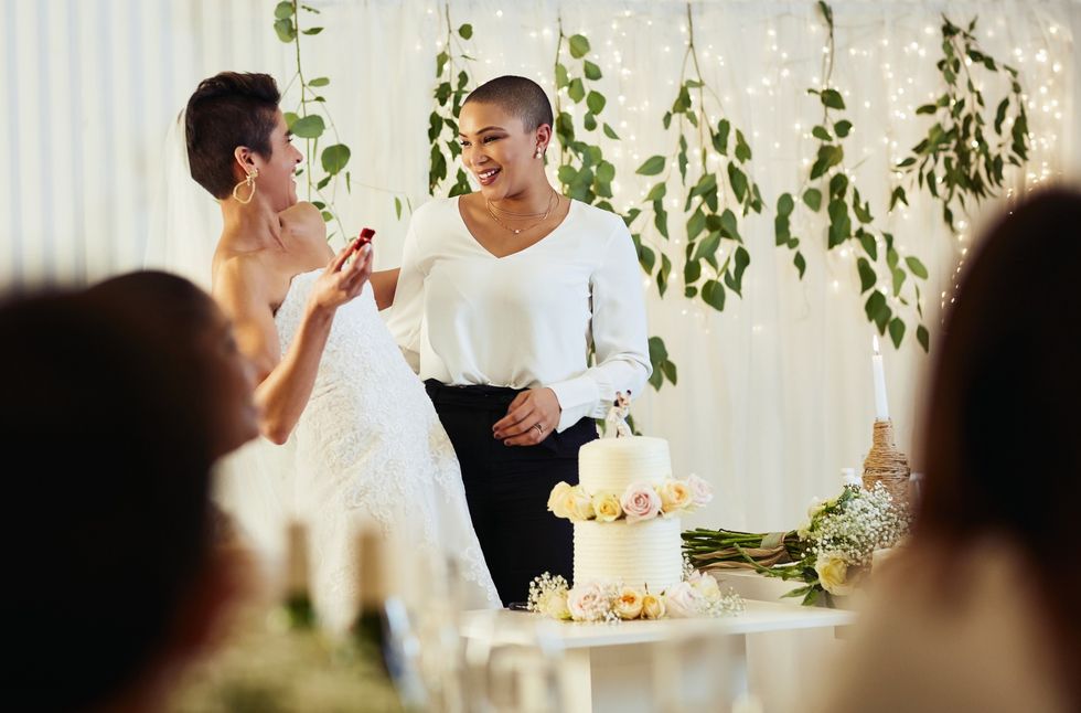 \u200bCropped-shot-of-affectionate-young-lesbian-bride-laughing-with-her-new-wife-while-having-cake-at-wedding-reception