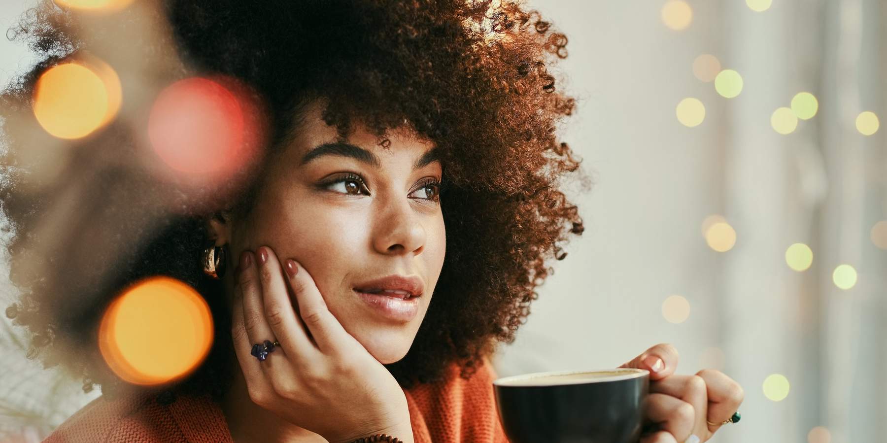 Woman-gazing-thoughtfully-as-she-sips-her-warm-beverage-tea