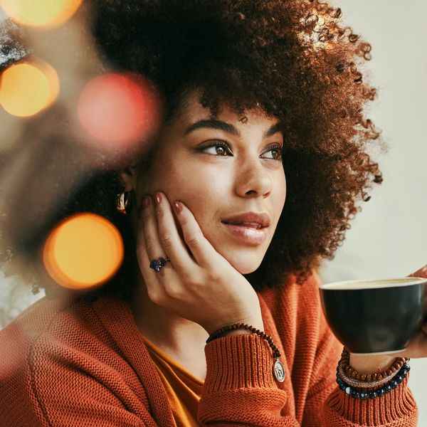 Woman-gazing-thoughtfully-as-she-sips-her-warm-beverage-tea