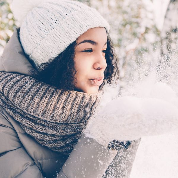 woman-in-a-winter-wonderland-blowing-snow-from-her-hands-in-playful-way