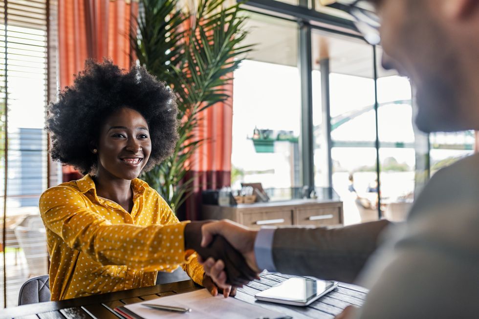 Woman-smiling-in-job-interview-shaking-hiring-manager-hand