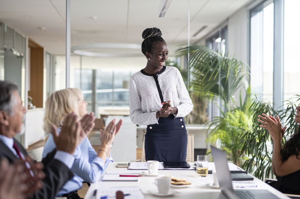 woman-smiling-while-presenting-in-meeting-to-the-applause-of-her-teammates