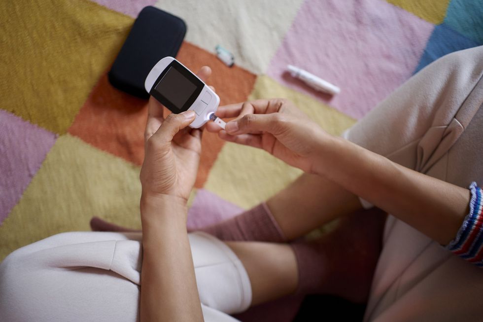 Woman-using-device-to-test-blood-sugar-levels-in-her-home
