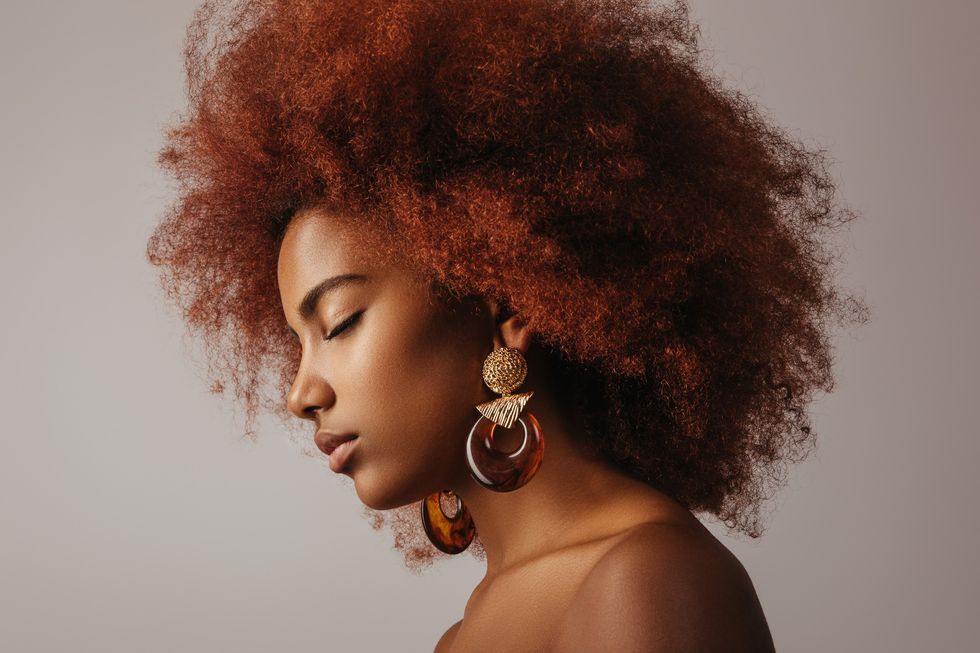 woman-with-eyes-closed-with-big-copper-colored-afro-hair