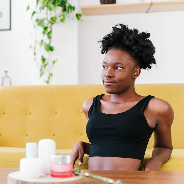 Young-African-American-woman-relaxing-on-the-floor-of-her-living-room-looking-away