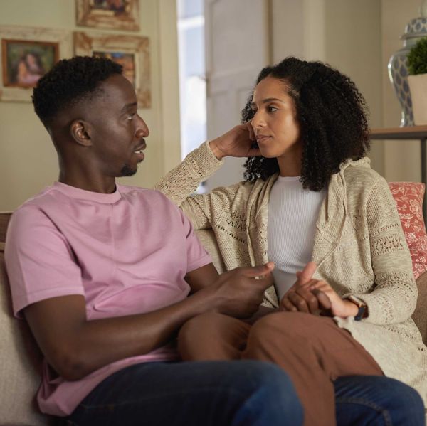 Young multiracial couple having an intimate conversation on their living room sofa, emotional connection and healthy communication