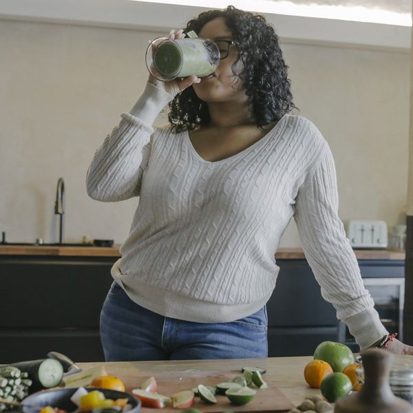 Young-woman-enjoying-delicious-healthy-smoothie-in-her-kitchen
