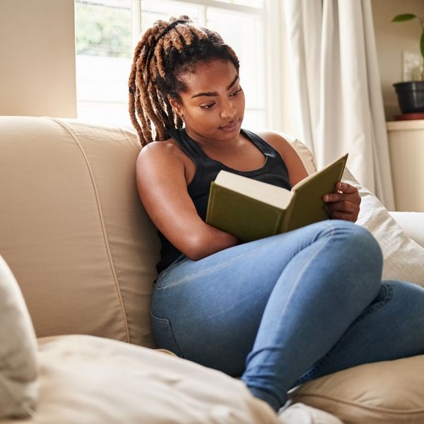 young-woman-sitting-on-the-couch-reading-a-book