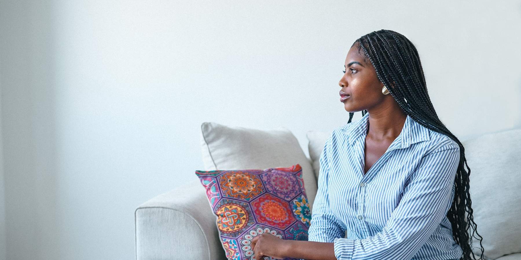 Young-woman-sitting-thinking-on-the-couch