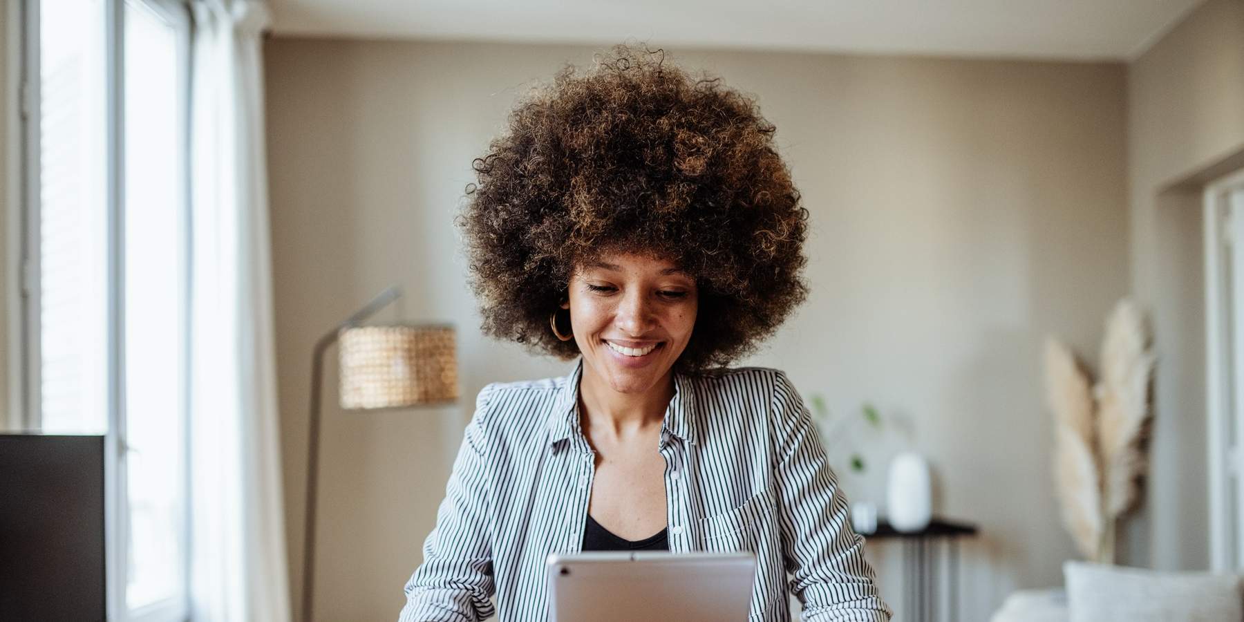 young-woman-smiling-looking-at-personal-tablet