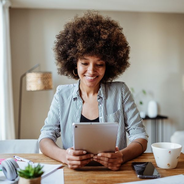 young-woman-smiling-looking-at-personal-tablet