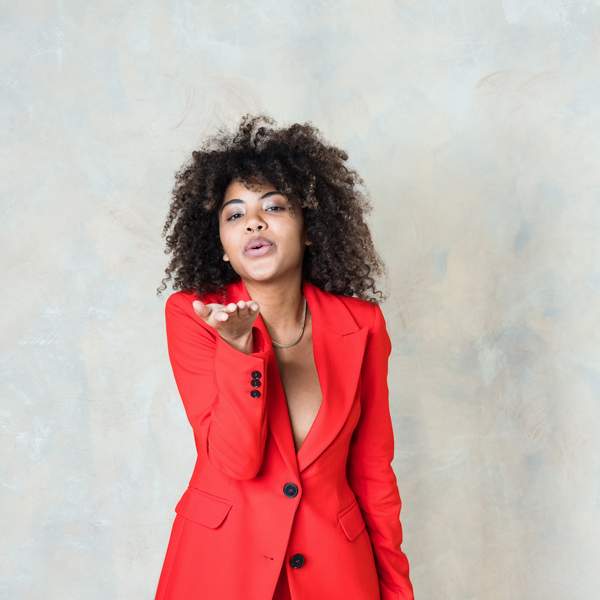 Young-woman-wearing-red-suit-blowing-a-kiss