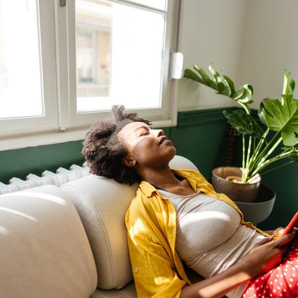 young-woman-with-eyes-closed-resting-on-her-couch-unplugging