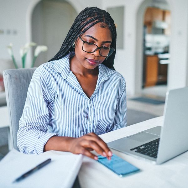 young-woman-working-on-her-budget-at-home-on-tablet-and-laptop
